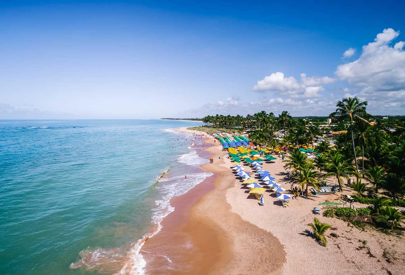 Vista panorâmica da Praia do Forte próxima a Salvador com o mar tranquilo e guarda-sóis