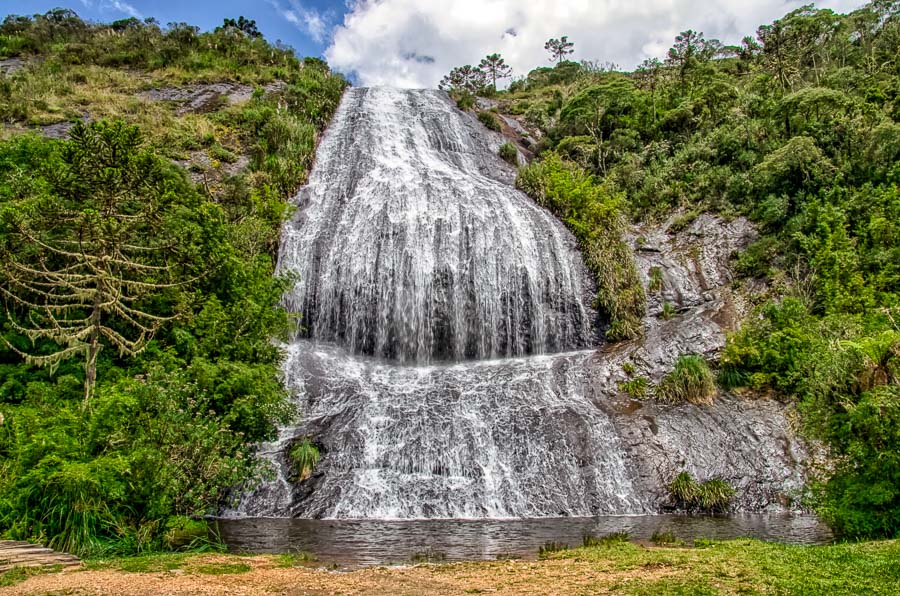 Queda d'água da Cachoeira Véu de Noiva em Urubici caindo sobre paredão rochoso e formação um poço entre a natureza