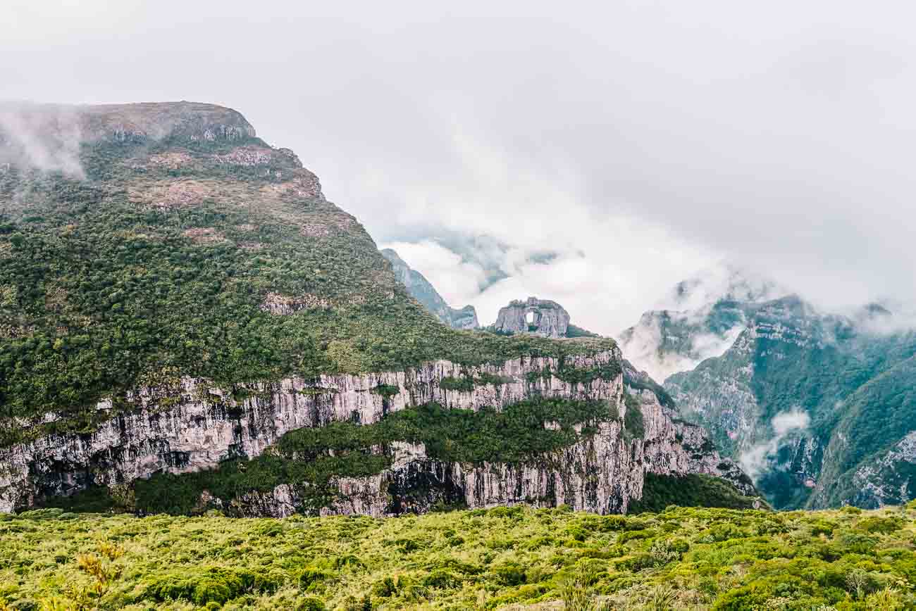 Topo do Morro da Igreja em Urubici e ao fundo, montanha com vegetação e a formação da Pedra Furada