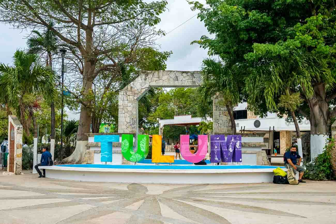 Letreiro colorido escrito "Tulum" em praça da cidade.