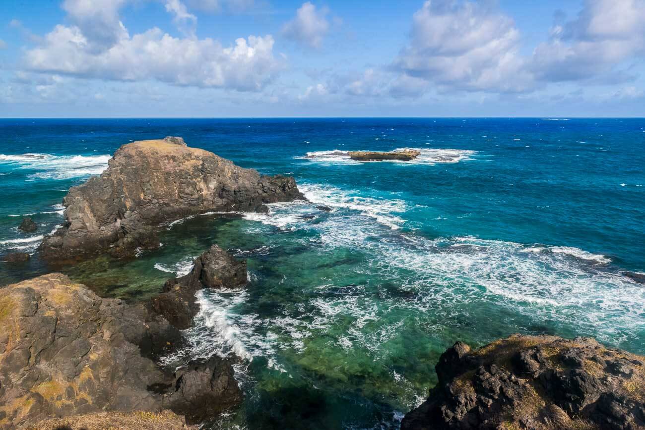 Formações rochosas com o mar forte cristalino no Buraco da Raquel