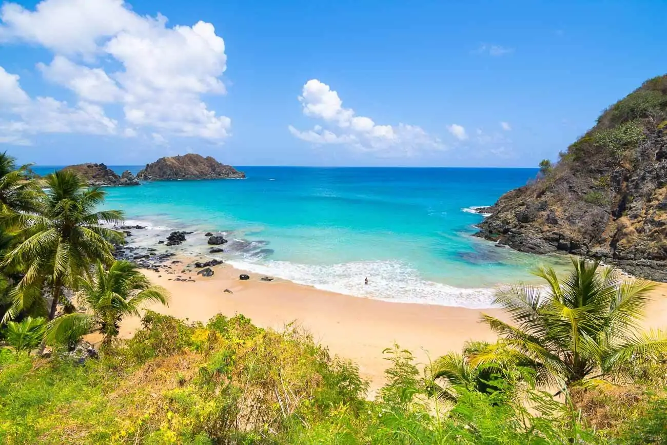 Vista panorâmica da Praia do Cachorro em Fernando de Noronha, com o mar azul turquesa.