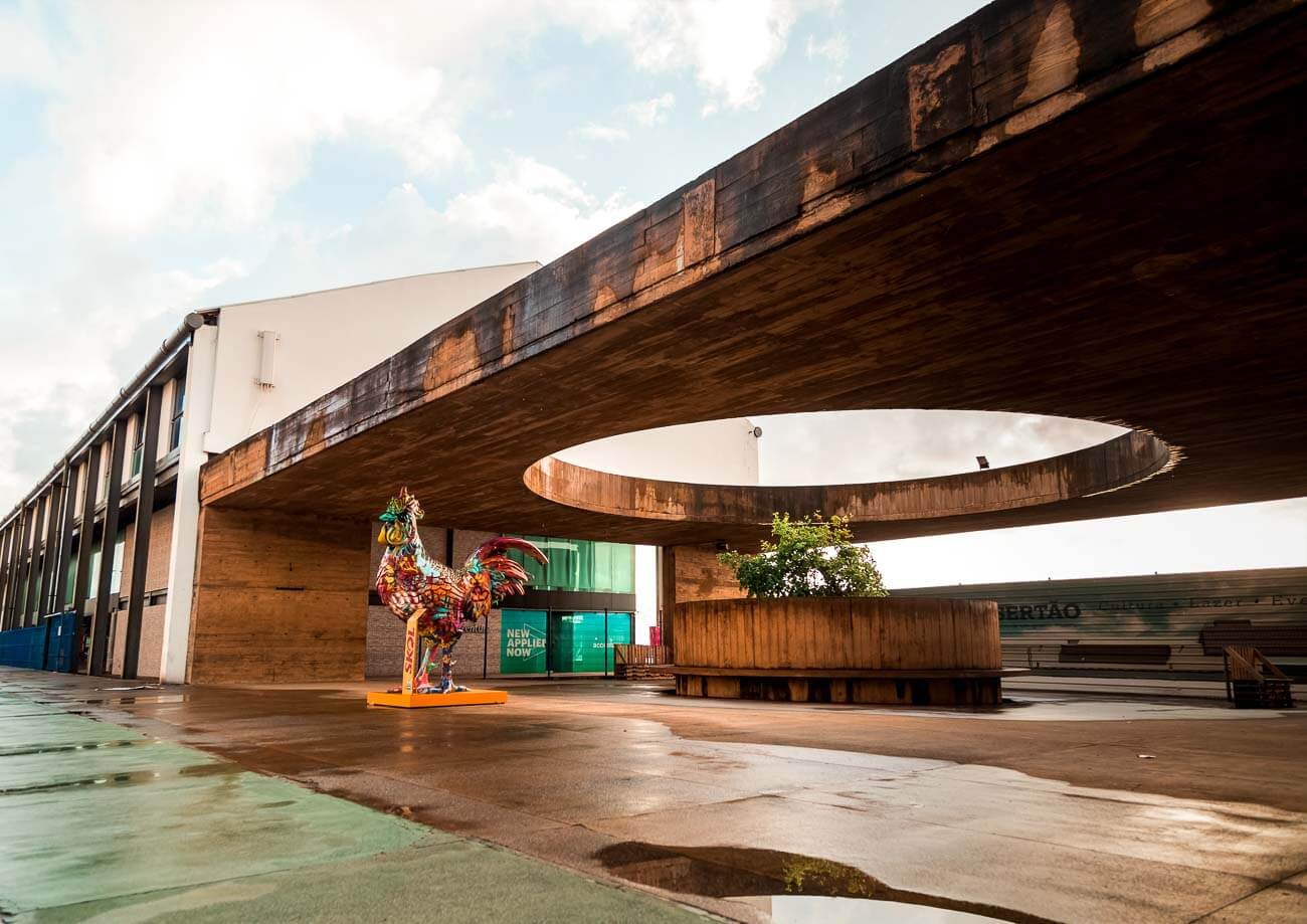 Uma escultura de galinha pintada com várias cores em uma das entradas do Cais do Sertão em Recife.