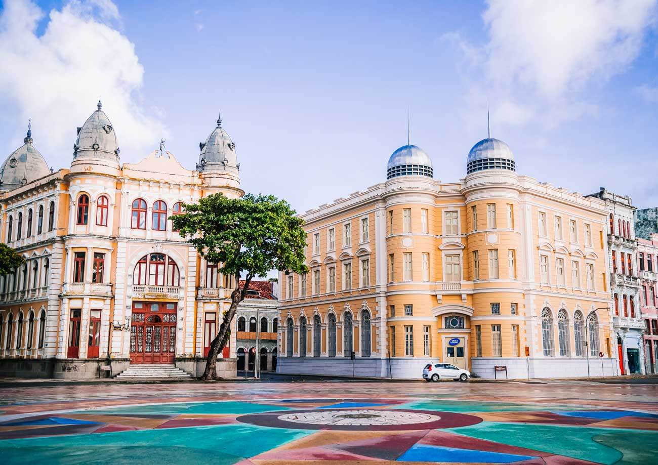 Praça do Marco Zero em Recife com casarões históricos ao fundo.