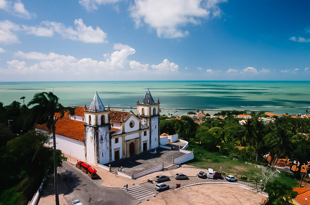 Vista de cima e panorâmica da Igreja da Sé em Olinda e o mar ao fundo.