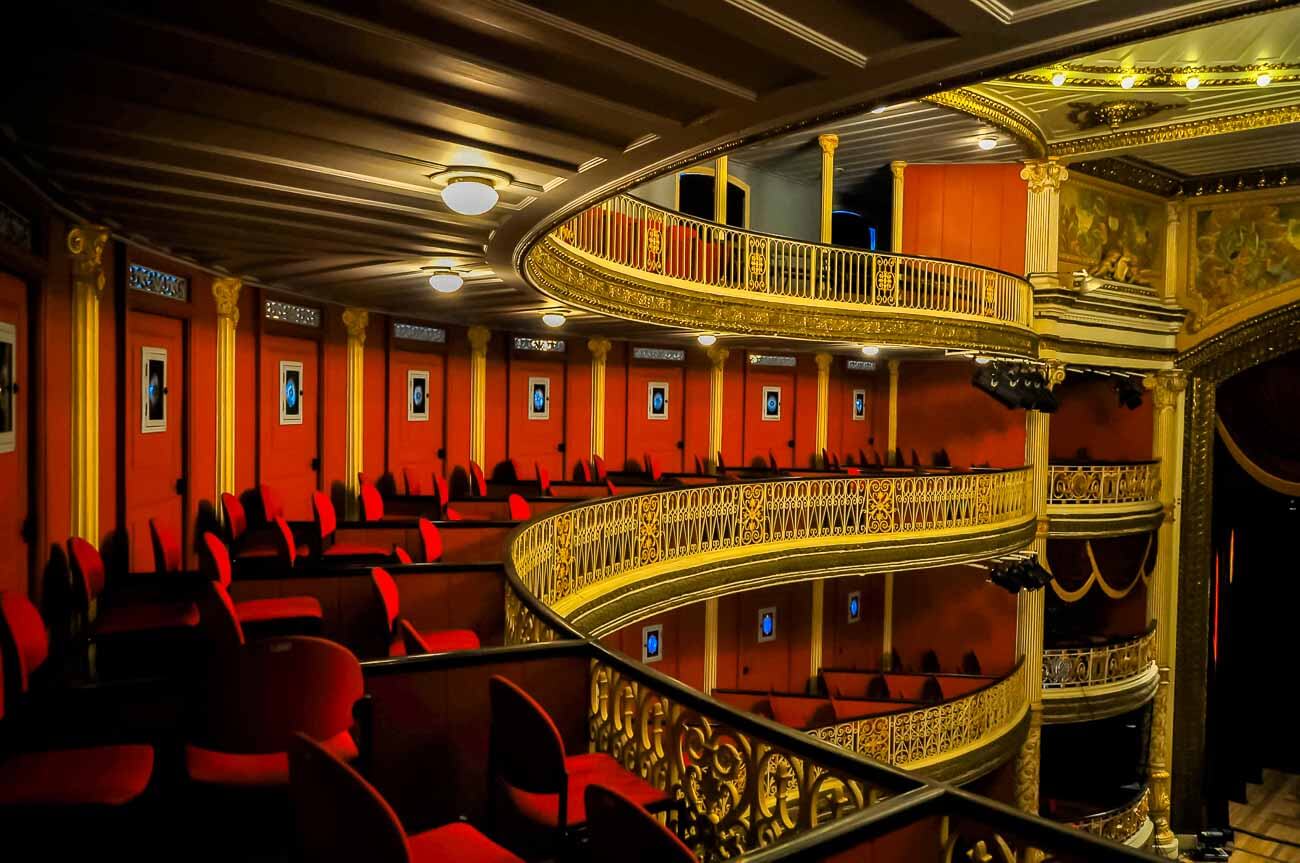 Interior do Teatro de Santa Isabel em Recife com assentos em cadeiras vermelhas e detalhes em dourado.