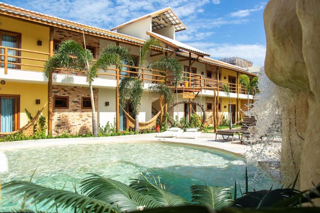 Área com piscina ao ar livre na Pousada Paraiso dos Ventos Preá com arquitetura rústica.