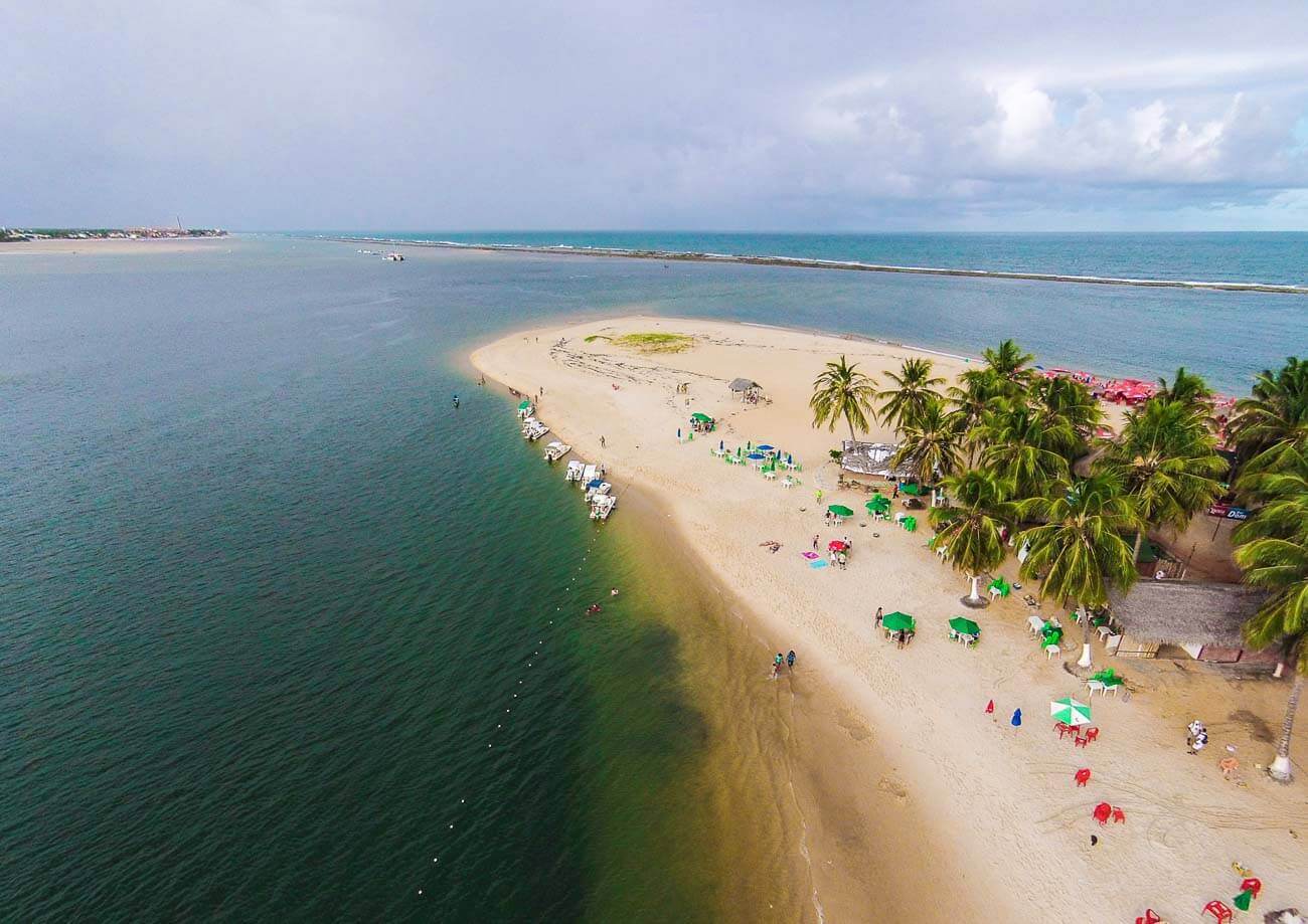 Vista de cima da Praia do Gunga, com o mar do lado direito e esquerdo. Ao fundo, a barreira de corais.
