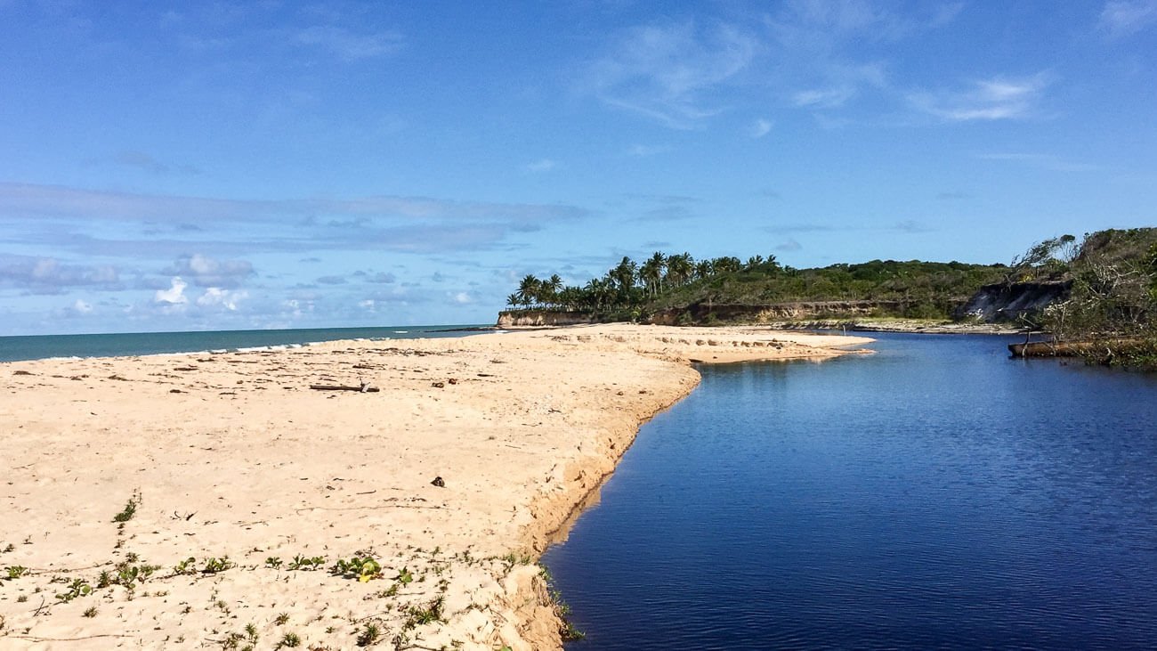 Faixa de areia dividindo o mar com o rio em Corumbau, Bahia.