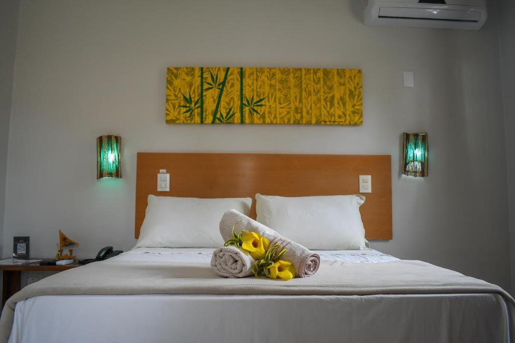 Quarto de casal com decoração alegre e cobre leito branco.