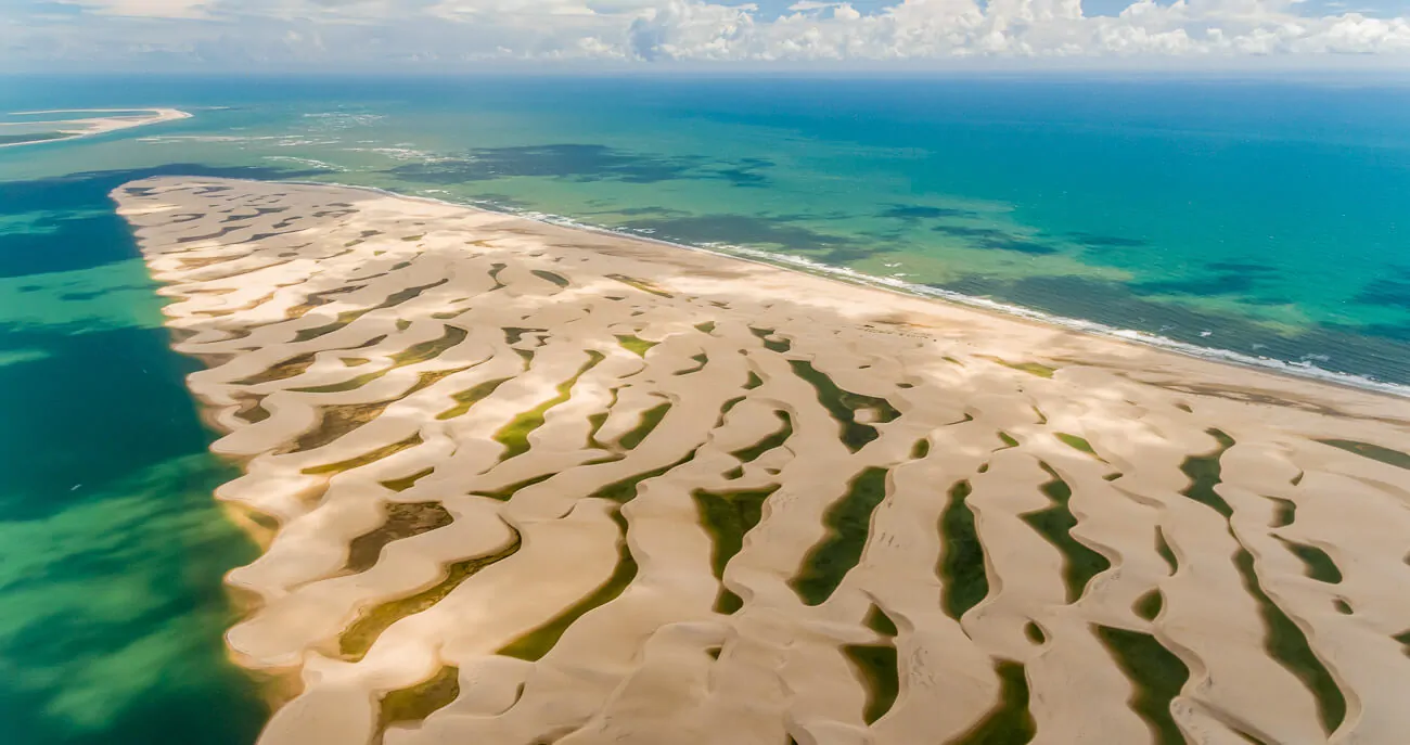 Vista de cima da Ilha Melancieiras, com formações de dunas e lagoas de água doce entre elas. Ao redor, o mar.