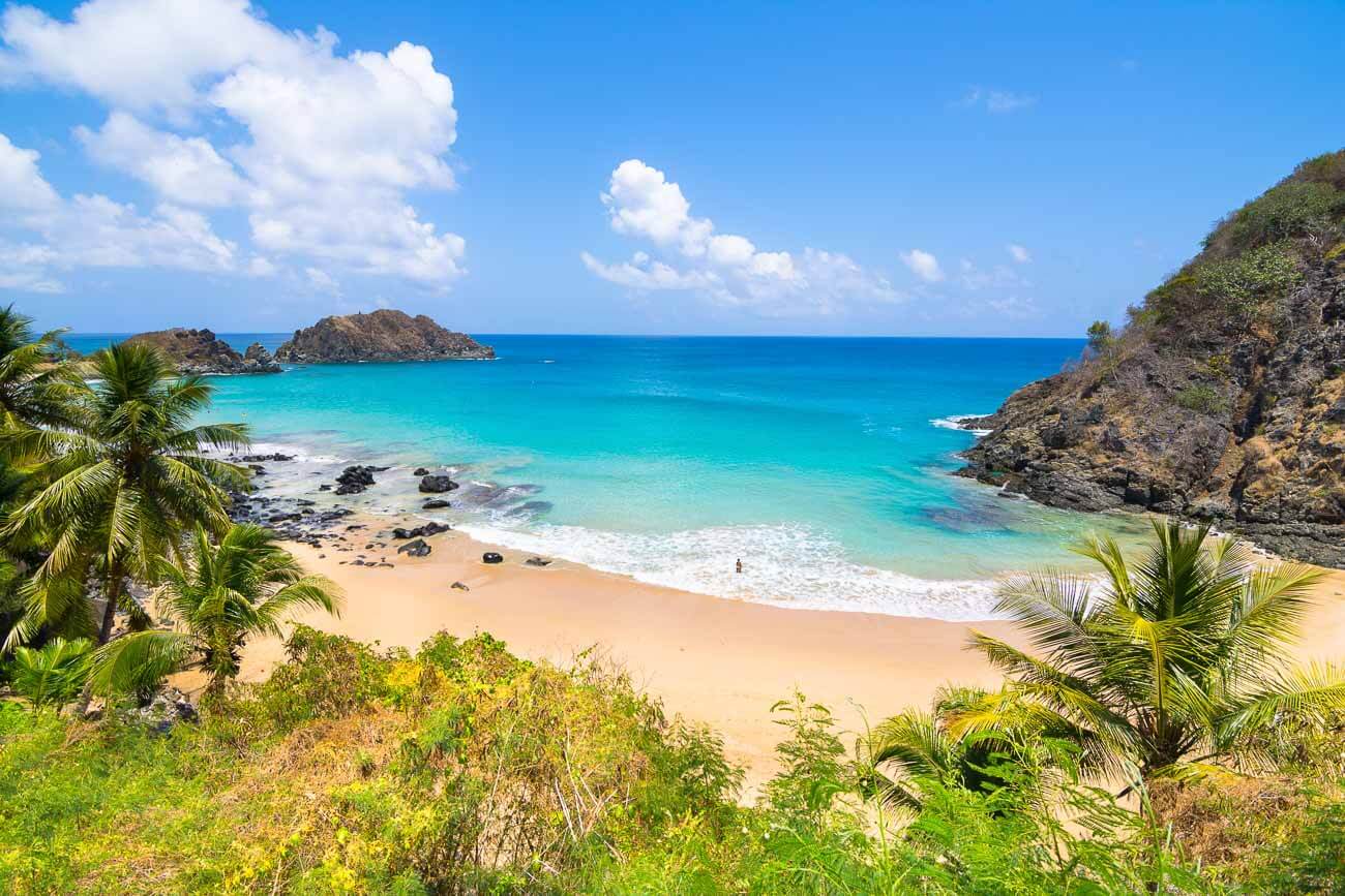 Vista panorâmica da Praia do Cachorro em Fernando de Noronha, com o mar azul turquesa.