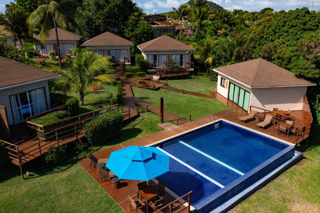 Área de lazer com grama e piscina ao ar livre em pousada em Fernando de Noronha.