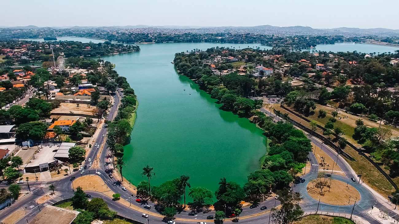 Vista de cima da Lagoa da Pampulha em Belo Horizonte com a cor verde escura cercada por natureza.