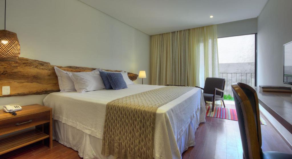 Quarto de casal com decoração elegante em hotel em Manaus com sacada.