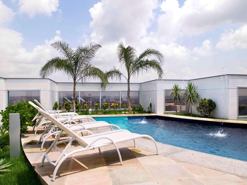 Piscina ao ar livre com espreguiçadeiras, ficando no terraço de um hotel em Manaus.