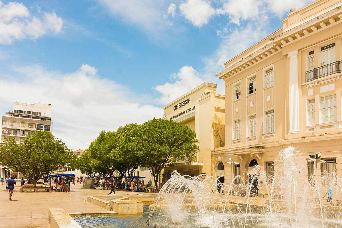Praça da Sé em Salvador com uma chafariz e feirinha de artesanato ao fundo.