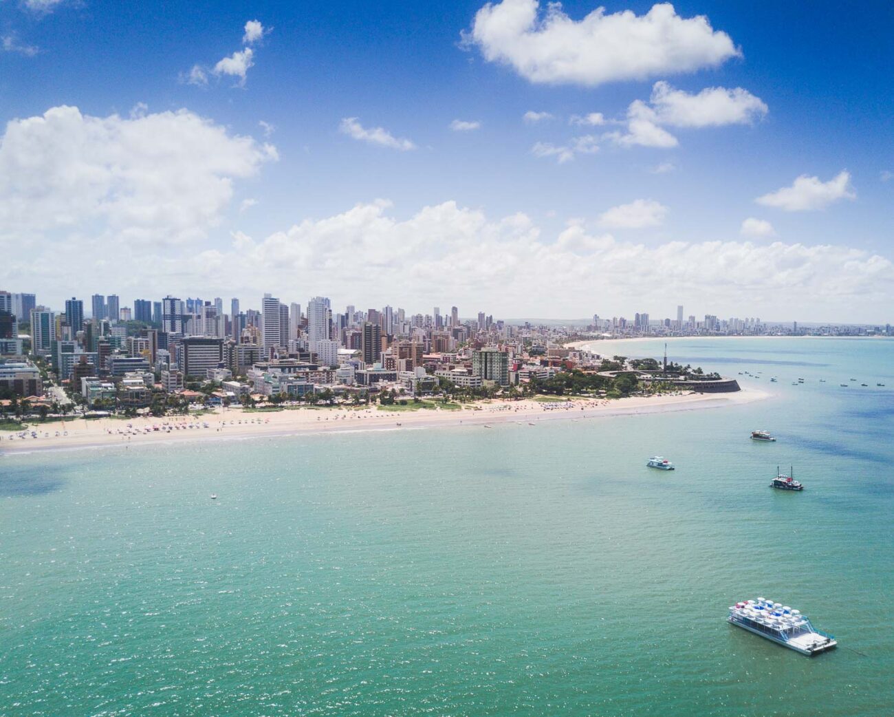 Vista área de uma parte da orla de João Pessoa com os prédios ao fundo.