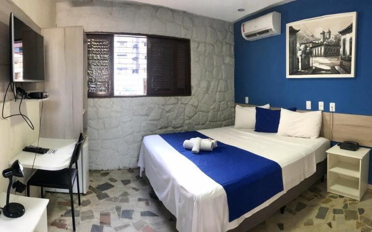 Quarto de casal com decoração em tons de azul.