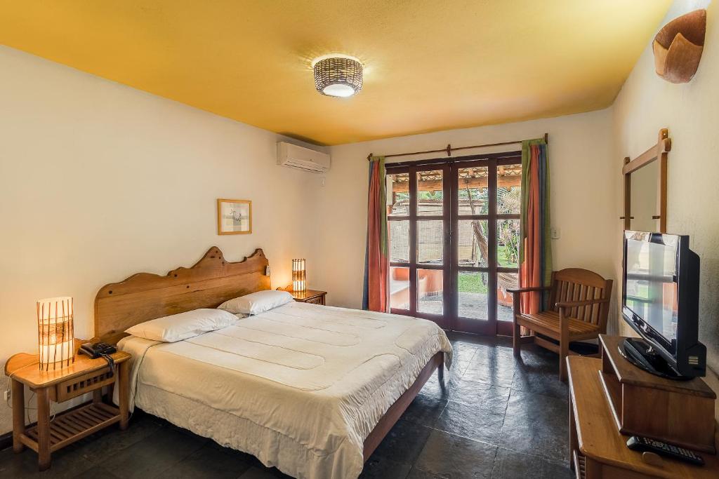 Quarto de casal espaçoso com móveis rústicos e praianos.