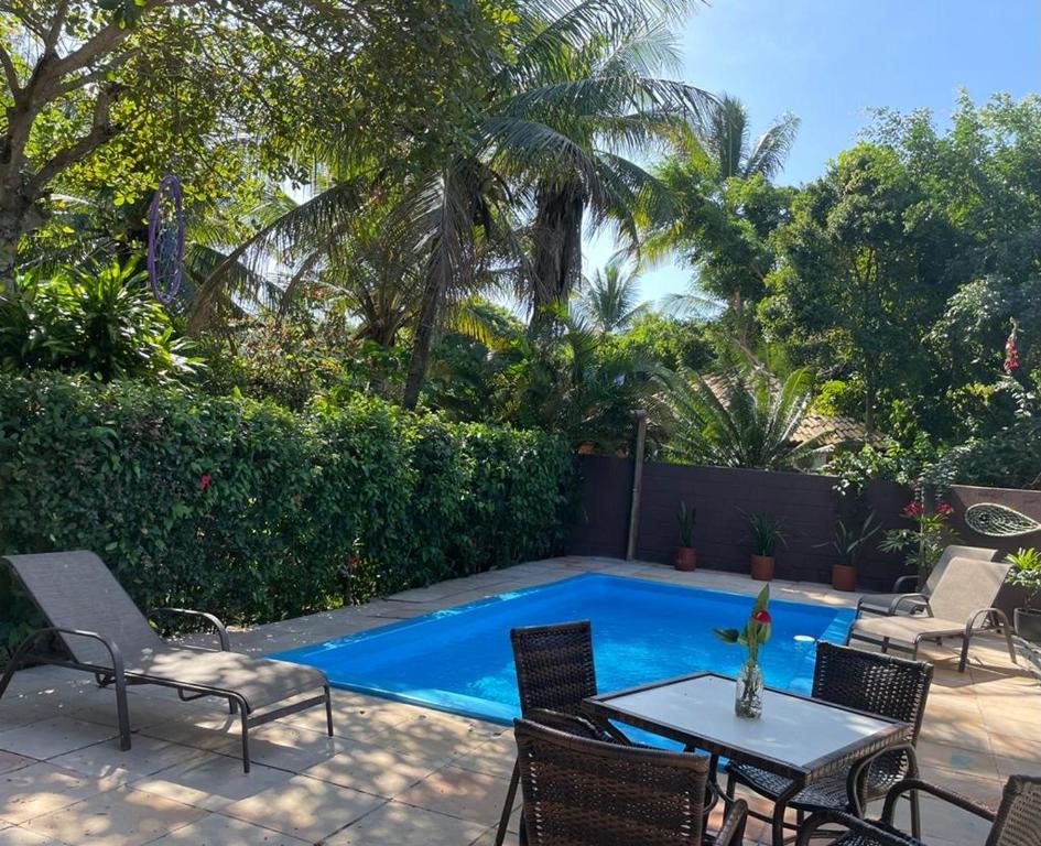 Piscina ao ar livre com espreguiçadeira, mesa e cadeiras.