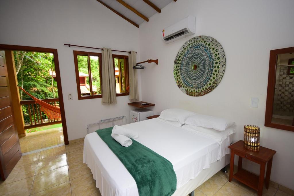 Quarto de casal com decoração rústica praiana e sacada com rede.