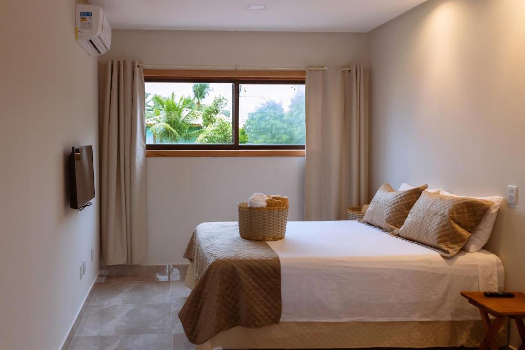 Quarto de casal com decoração clean em tons de branco e bege.