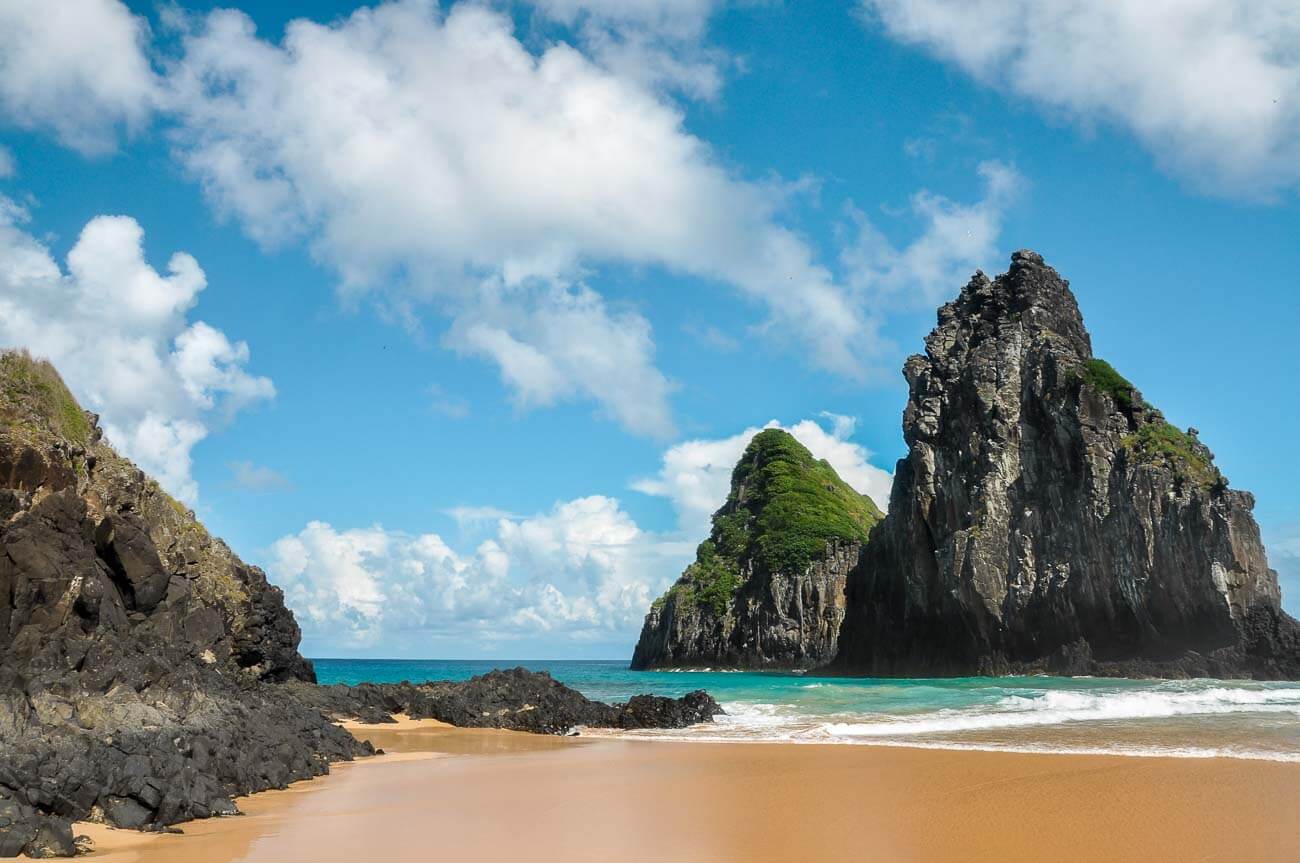 Formações rochosas na areia e no mar da Praia Cacimba do Padre em Fernando de Noronha