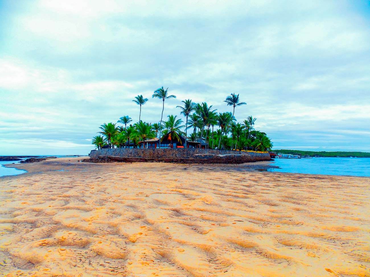 Área na Praia do Apaga Fogo com construção e coqueiros ao redor.
