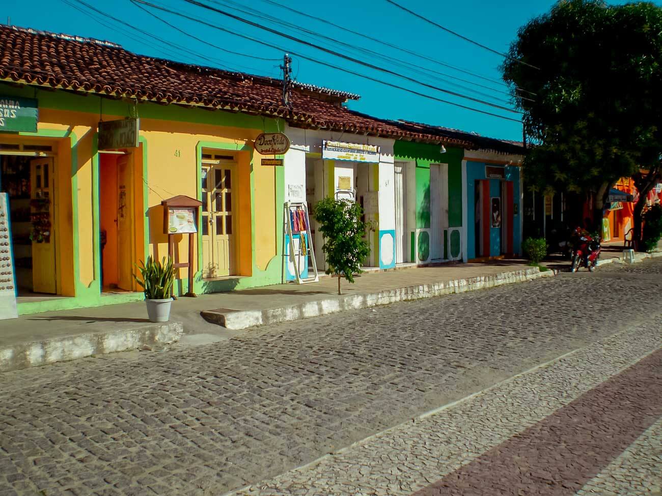 Rua Broadway em Arraial d'Ajuda de paralelepípedo e com lojinhas do lado esquerdo.