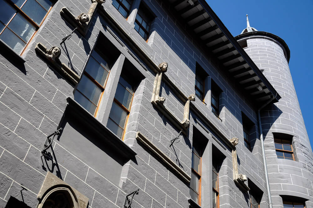 Fachada do Maison Tavel, com paredes de pedra cinzas e arquitetura medieval, em Genebra.
