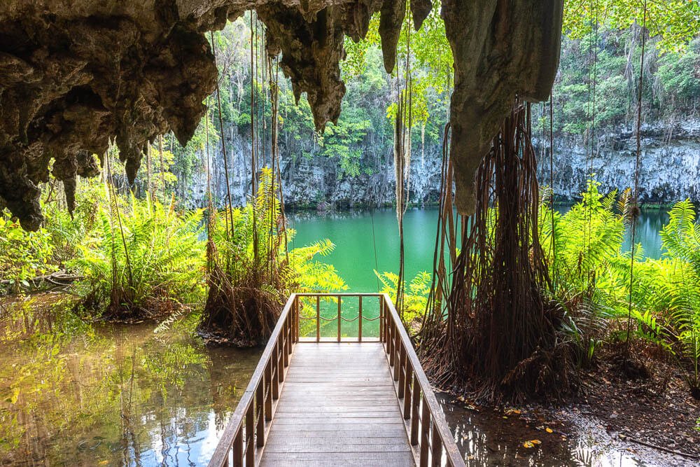 Guarda-corpo em frente à lago subterrâneo cercado por vegetação, em Santo Domingo, na República Dominicana