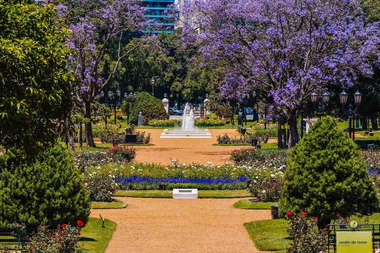 Área repleta de canteiros de flores e árvores no Parque Tres de Febrero