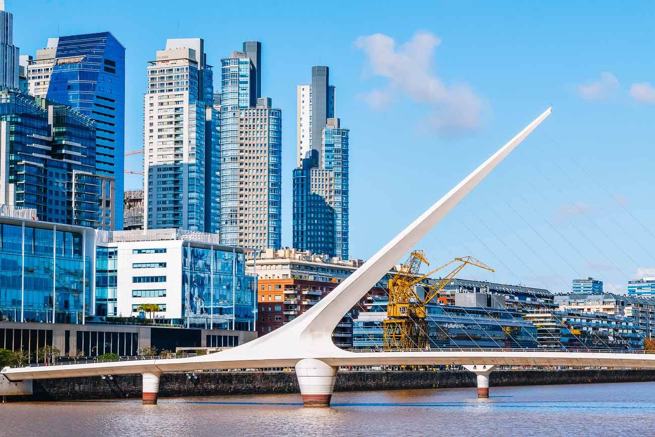 Vista da Puente de la Mujer em Puerto Madero, Buenos Aires, ficando sobre o Rio de la Prata. Ao fundo, prédios modernos.