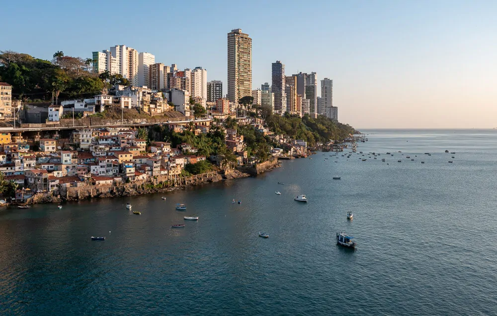 Praia da Gamboa com mar de águas escuras e imóveis à beira-mar.