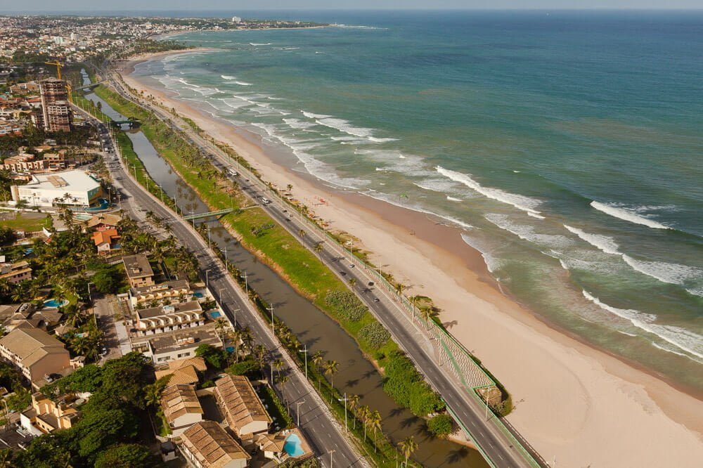Praia de Jaguaribe com rio à esquerda e mar à direita.