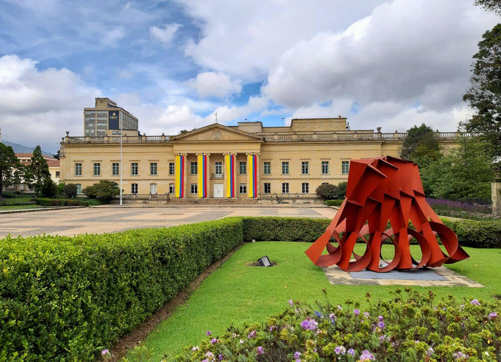 Jardim da Casa de Nariño com pátio grande e escultura à direita.