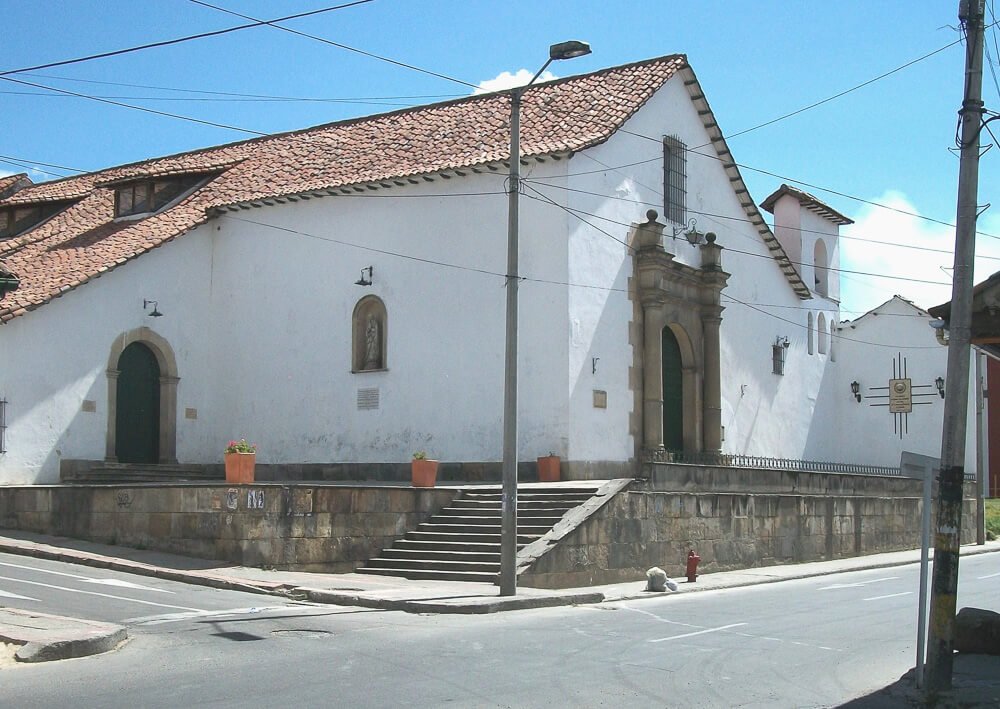 Fachada lateral da Igreja de Santa Bárbara com escada lateral e uma rua em frente à igreja.