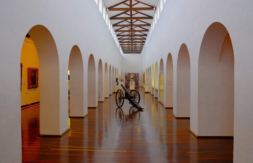 Corredor interno do Museu Nacional da Colômbia. Há um canhão antigo no meio.