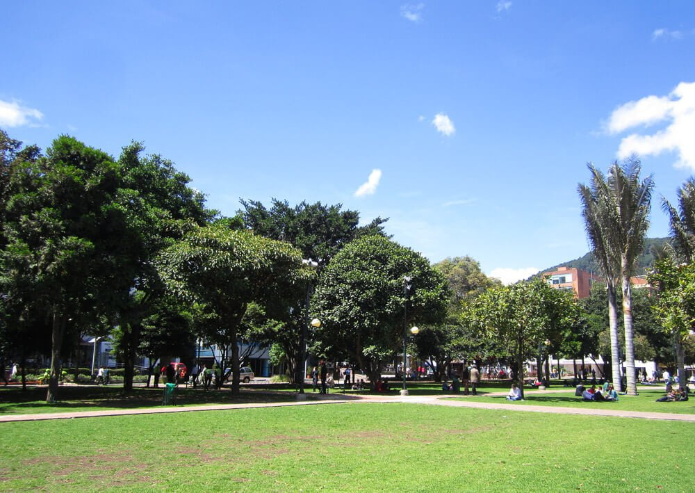 Gramado com muitas árvores no Parque 93, em Bogotá.
