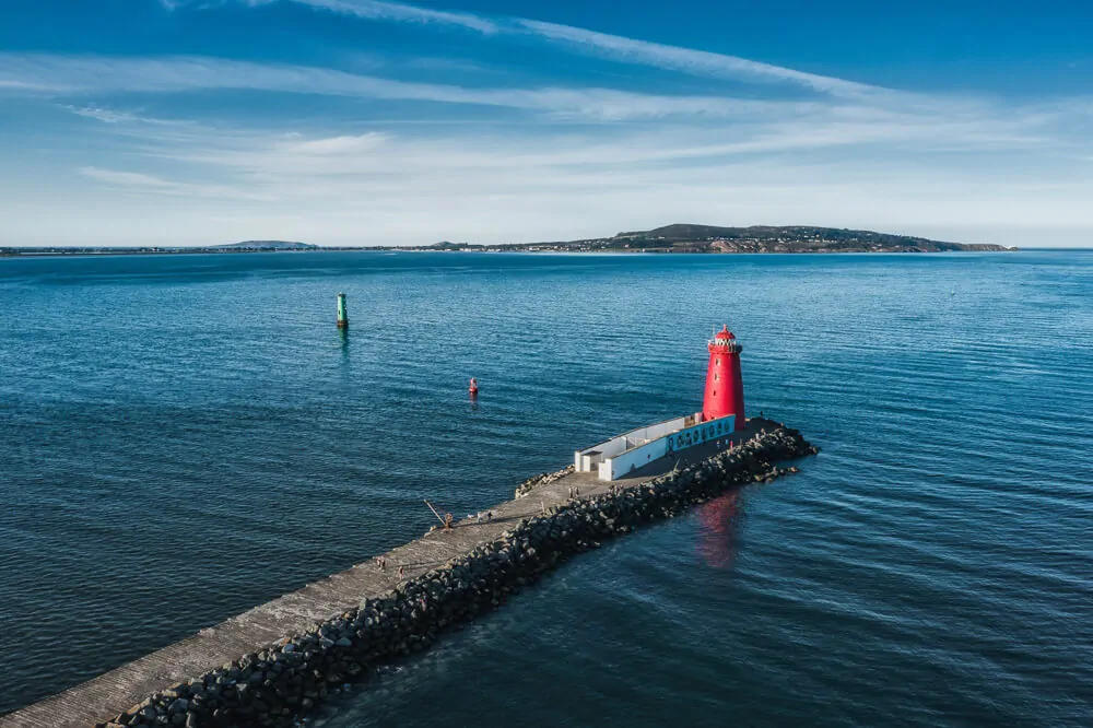 Farol de Poolbeg no meio do mar de águas azuis.