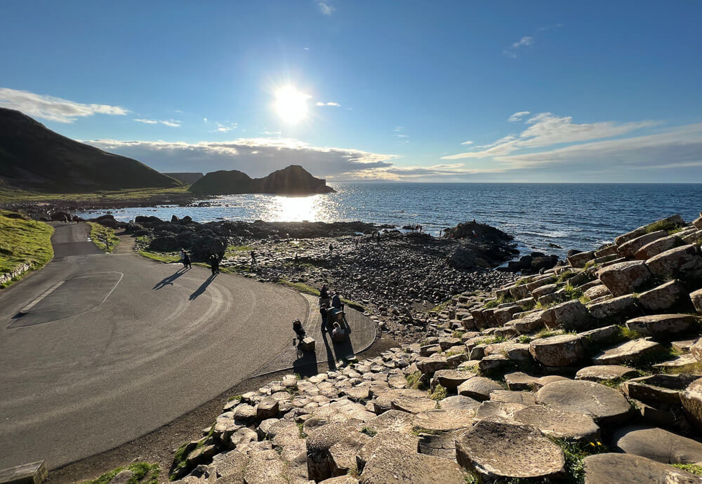 Giant’s Causeway com estrada à esquerda e mar à direita.