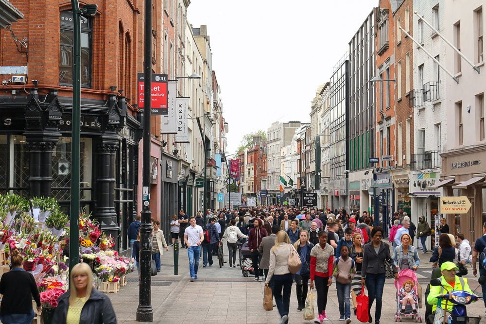 Rua Grafton Street com muitas pessoas caminhando.