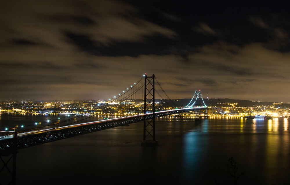 Ponte 25 de abril iluminada em uma noite de Lisboa.