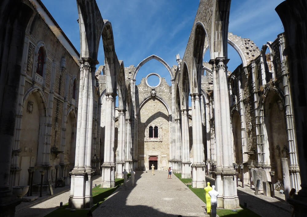 Ruínas do Convento do Carmo, em Lisboa. Há vários arcos brancos no local sem telhado.