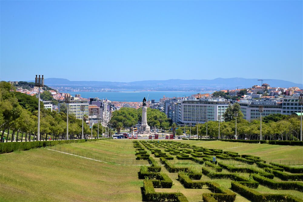Extenso jardim em forma de labirínto no Parque Eduardo VII. Ao fundo, está os prédios da cidade e o rio.