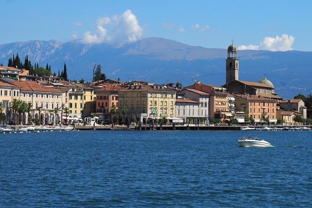 Lago de Garda com águas cristalinas e prédios na região costeira.