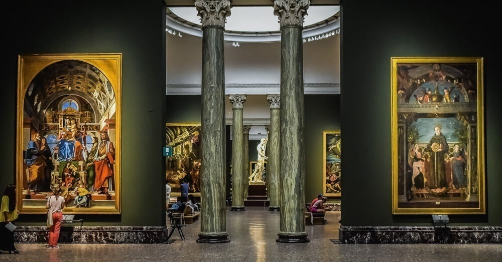 Interior da Pinacoteca de Brera. Há quadros tanto na esquerda, quanto na direita.