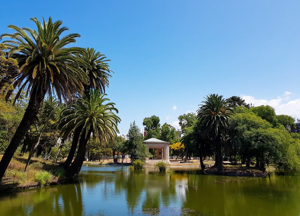 Parque Rodó com muitas árvores e um lago com águas verdes.