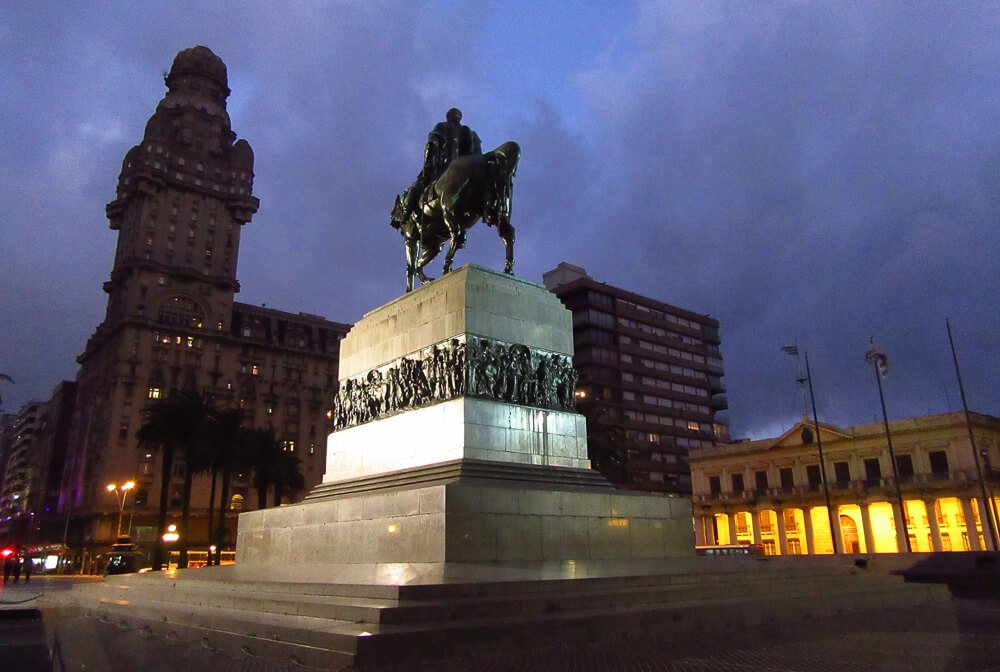 Plaza Independencia à noite. Há uma estátua equestre no centro.